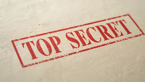 Red top secret stamp on textured paper distressed rectangular seal macro