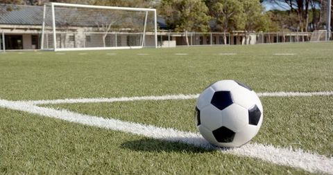 Soccer Ball on Synthetic Turf with Goalpost in Background