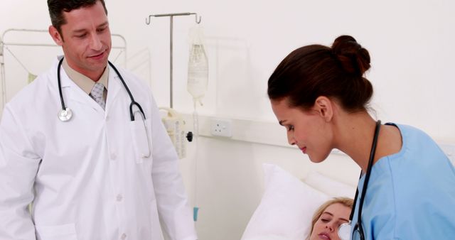 Doctor and nurse providing care to female patient in hospital room. This image is useful for medical websites, health care blogs, articles on patient care, hospital promotional materials, and educational content on medical treatment.