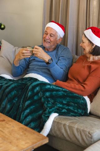 Elderly Couple Unwrapping Gift During Cozy Christmas Gathering