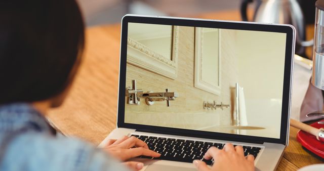 Image of person using laptop with house bathroom interiors displayed on screen. Online shopping house decorating concept digital composite.