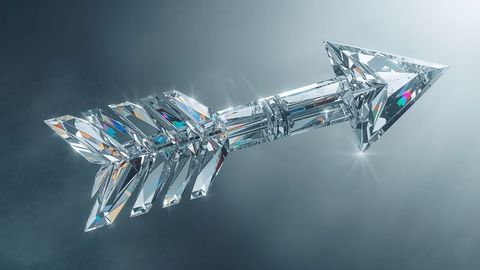 Floating faceted crystal arrow refracting light in studio