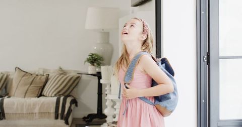 Joyful Girl with Backpack at Home After School