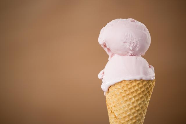 Close-up of double scoop strawberry ice cream in a waffle cone