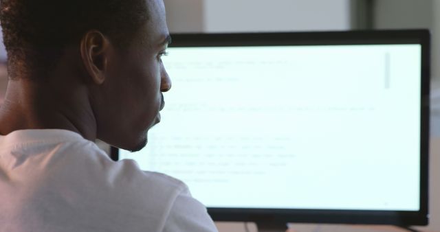 Rear view of black male executive working on computer at desk in office. Black male executive sitting on desk 4k