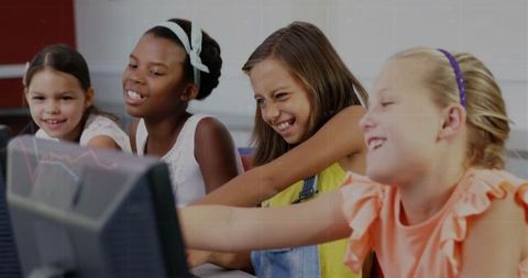 Diverse students engaging with computers in classroom setting