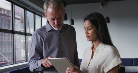 Colleagues Discussing Project on Tablet in Office Setting