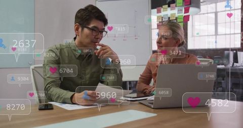 Business Professionals Analyzing Social Media Metrics in Modern Office