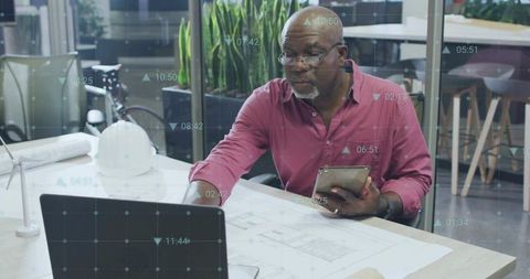 Senior Engineer Engaging with Technological Blueprints in Modern Office