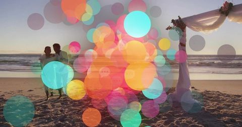 Newlywed couple sharing quiet moment by sunlit beach arch