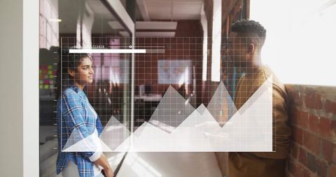 this visual portrays two colleagues engaged in a business discussion with a digital analytics graph overlay, indicating a modern workplace environment focused on data-driven decision making. ideal for company presentations, articles about diversity in business, and digital marketing materials emphasizing teamwork and technology.