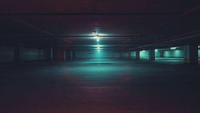Spacious empty underground parking garage with moody lighting