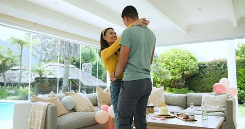 Young Couple Dancing Joyfully in Bright Living Room Celebration