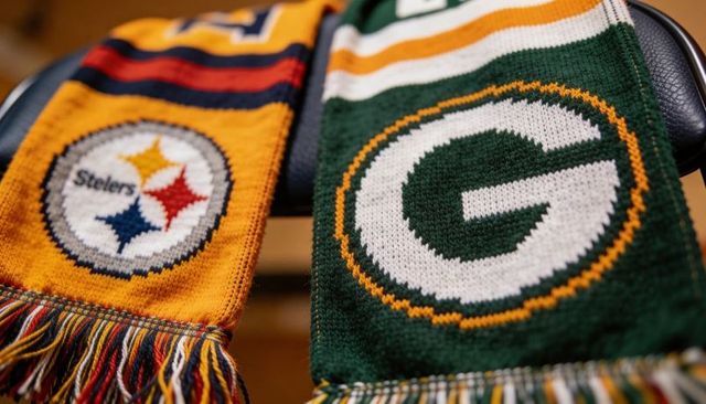 Draping nfl team knit scarves showing steelers and packers logos close-up texture cozy knit