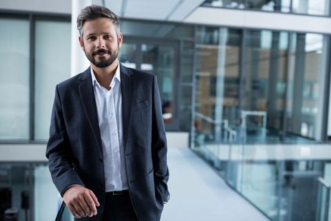 Confident businessman in modern office walkway