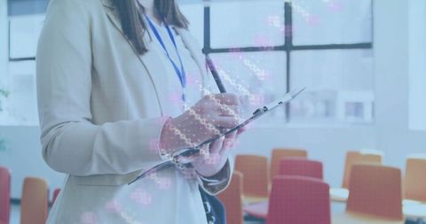 Businesswoman writing on clipboard in modern conference room