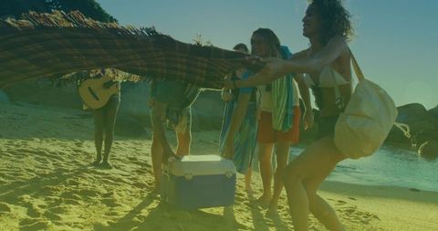 Diverse Friends Having Picnic by the Sea at Sunset