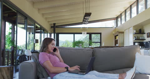 Pregnant Woman Relaxing on Sofa While Working Remotely at Home