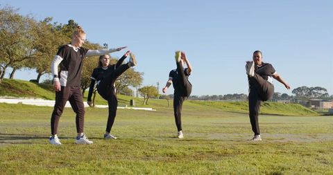 Diverse Female Athletes Exercising on Grassy Field