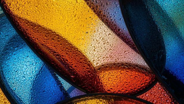 Vibrant overlapping colored glass panels with water droplets