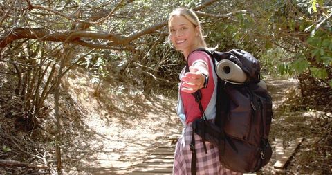 Adventurous Woman Enjoying Woodland Hike with Backpack and Smile