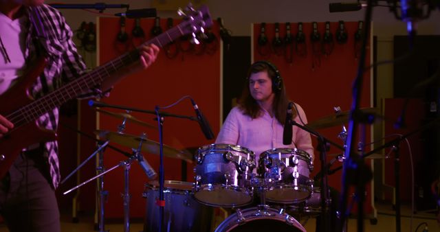 Teenage girl playing drum set in music studio, practicing her skills. This image is ideal for websites, blogs, or publications on topics such as music education, teenage musicians, and studio recordings.