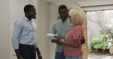 Real estate agent presenting agreement to couple in modern home
