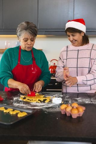Mother and Daughter Baking Cookies in Santa Hat for Festive Celebration