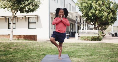 Young Girl Practicing Yoga Tree Pose Outdoors
