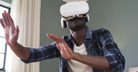 Man Experiencing Virtual World with VR Headset in Casual Home Environment