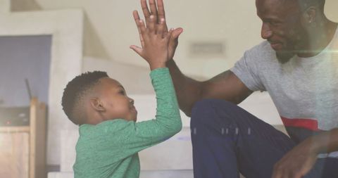 Father and Son Bonding with a High Five at Home