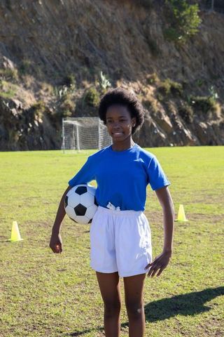 Teen African American Female Athlete with Soccer Ball Outdoors