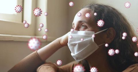 Pensive woman with face mask and floating virus particles