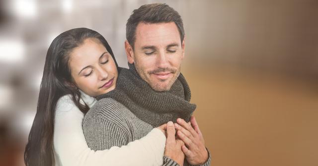 Digital composite of Loving couple in warm clothes embracing over blur background