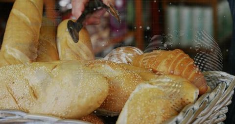 Hand using tongs picking sesame roll from bakery basket with world map overlay