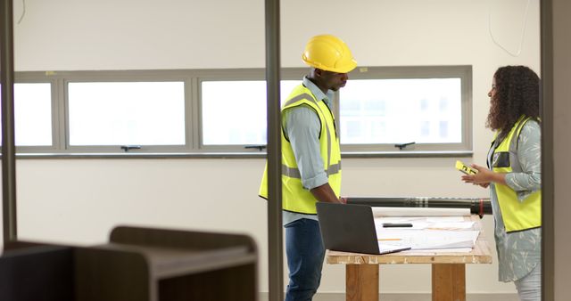 Architects Discussing Building Plans on Construction Site - Download Free Stock Images Pikwizard.com