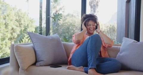 Relaxed Woman Enjoying Music on Sofa with Headphones