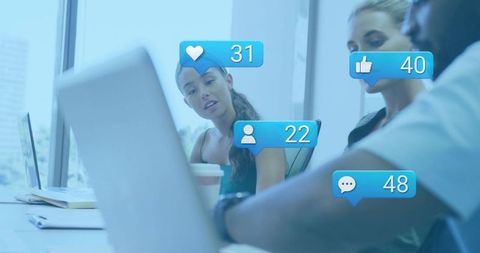 Team discussing social media engagement with notification bubbles while woman leaning on laptop