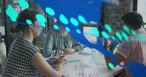 Design team collaborating over color swatches and charts with turquoise digital overlay