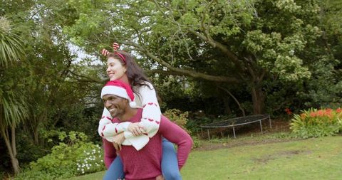 Festive couple enjoying christmas back yard piggyback ride