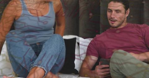 Young couple relaxing on sofa at home sharing smartphone casual cozy dating lifestyle