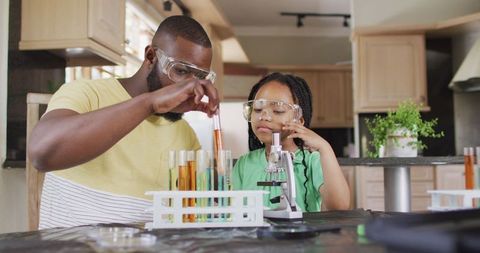Father and daughter conducting science experiments together at home