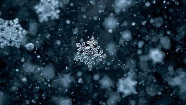 Intricate Snowflake Crystallizes Amidst Soft Glowing Snowfall