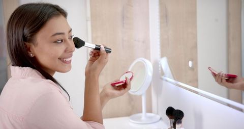 Smiling Woman Applying Makeup with Brush at Home Vanity - Download Free Stock Images Pikwizard.com
