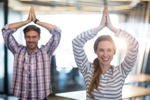 Business people practicing yoga in an office environment, promoting wellness and relaxation. Ideal for use in articles or advertisements related to corporate wellness programs, stress relief techniques, team building activities, and promoting a healthy lifestyle in the workplace.