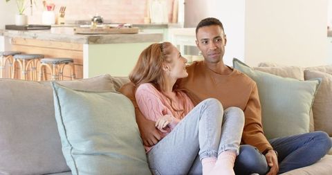 Diverse Couple Relaxing on Sofa in Modern Living Room
