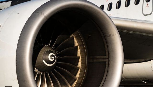 Sunlit turbofan engine close-up showing spiral spinner, multi-blade fan and nacelle details