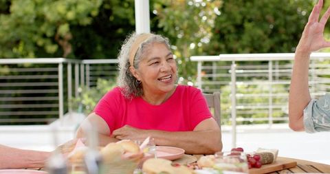 Elderly Woman Enjoying Outdoor Meal with Friends on Sunny Day - Download Free Stock Images Pikwizard.com