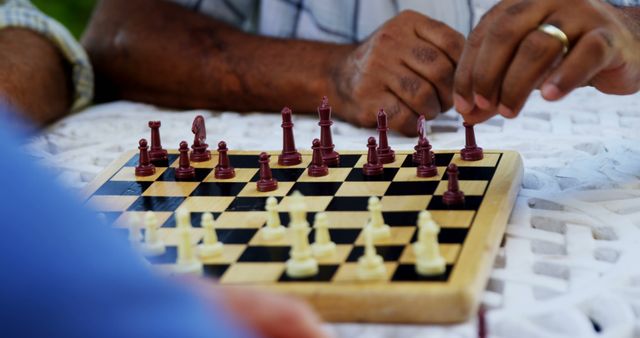 Two individuals are engaged in a game of chess, with one player contemplating their next move. Chess is a strategic board game that requires patience and skill, often reflecting the complexity of human intelligence and decision-making.