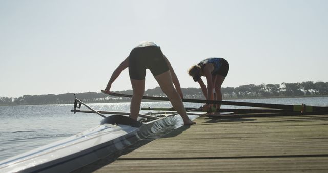 Female Rowers Preparing Boat by Lake on Sunny Day - Download Free Stock Images Pikwizard.com